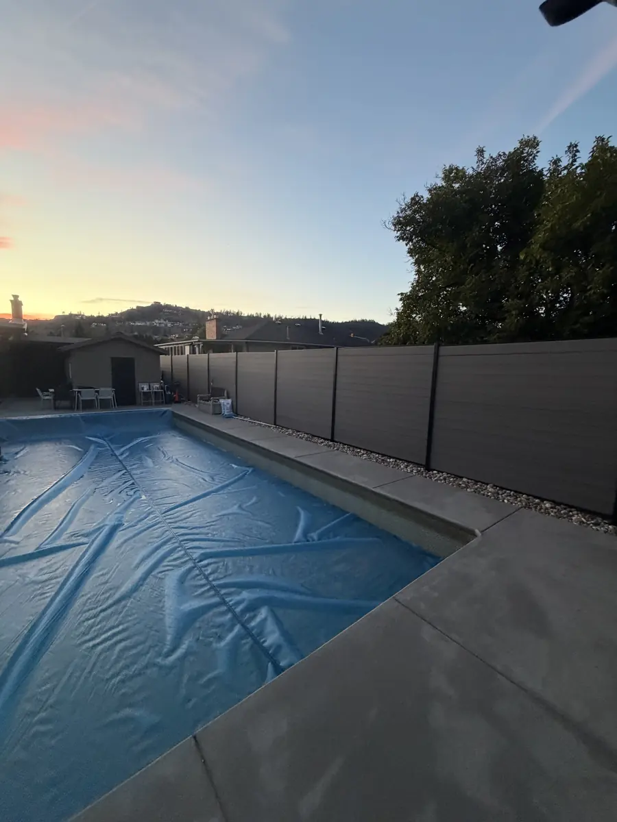 The pool yard with the new modern grey privacy fence