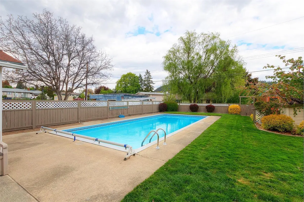 The old tan lattice-top fence around the pool before